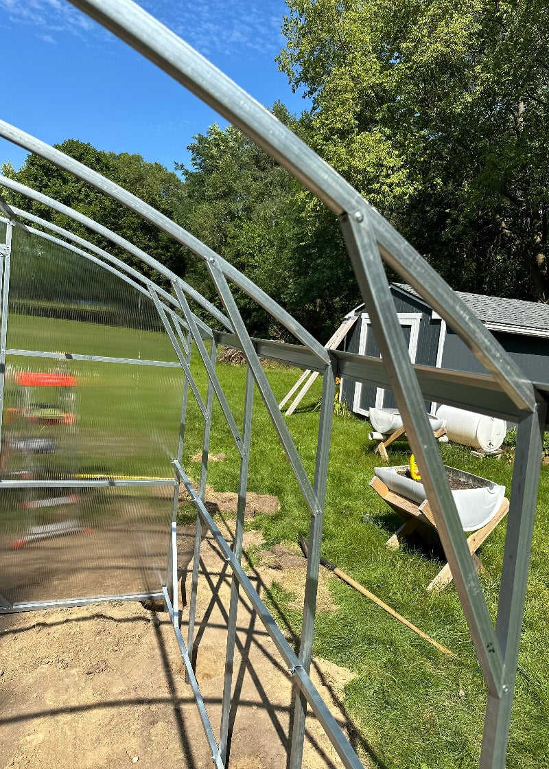 Heavy-duty greenhouse kit with galvanized steel frame and polycarbonate twin walls, designed to withstand harsh weather conditions.