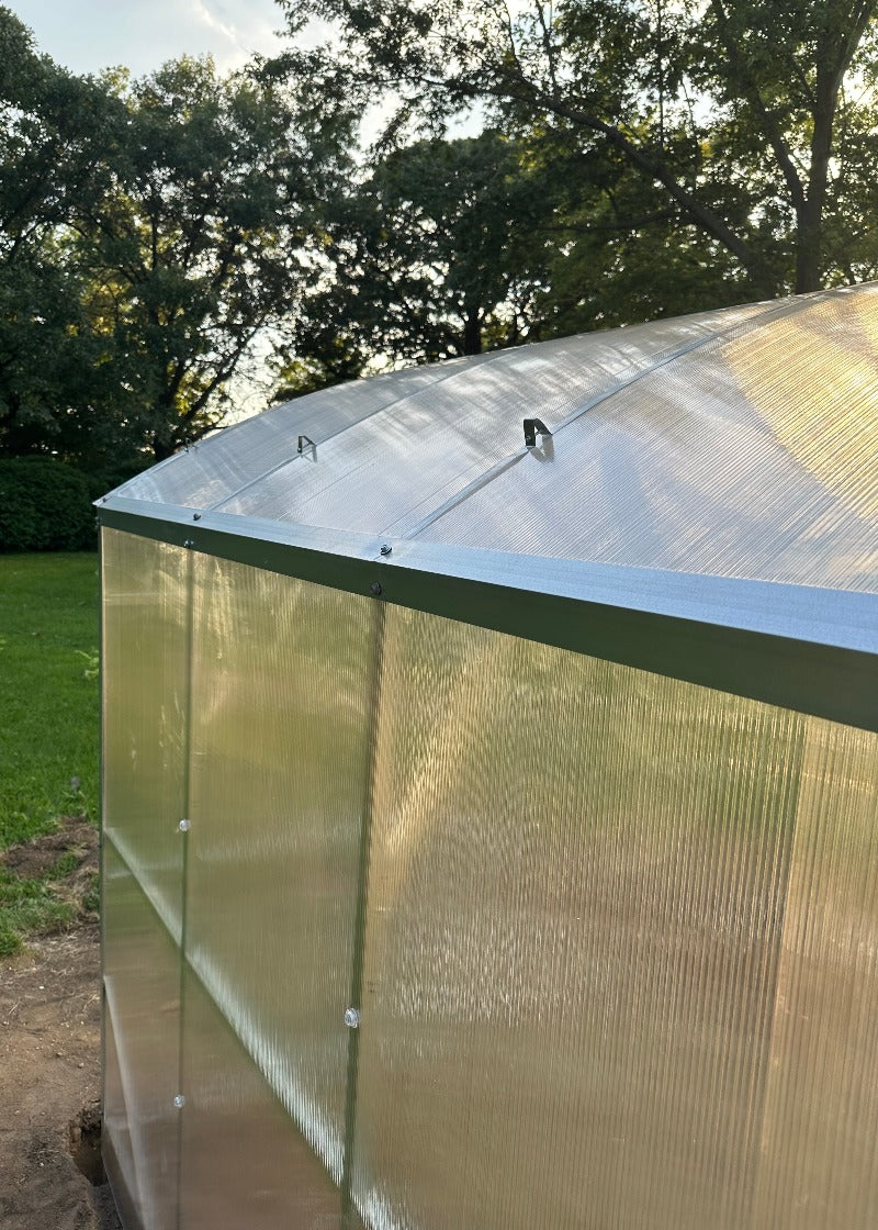 Heavy-duty greenhouse kit with galvanized steel frame and polycarbonate twin walls, designed to withstand harsh weather conditions.
