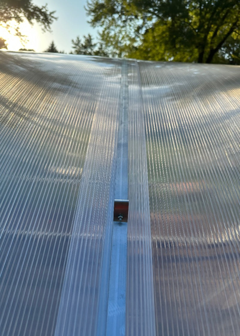 Heavy-duty greenhouse kit with galvanized steel frame and polycarbonate twin walls, designed to withstand harsh weather conditions.