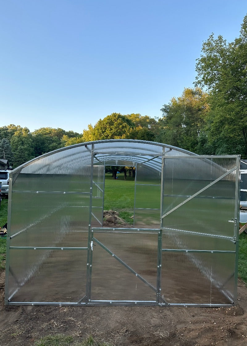 Heavy-duty greenhouse kit with galvanized steel frame and polycarbonate twin walls, designed to withstand harsh weather conditions.