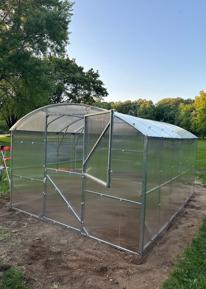 Heavy-duty greenhouse kit with galvanized steel frame and polycarbonate twin walls, designed to withstand harsh weather conditions.