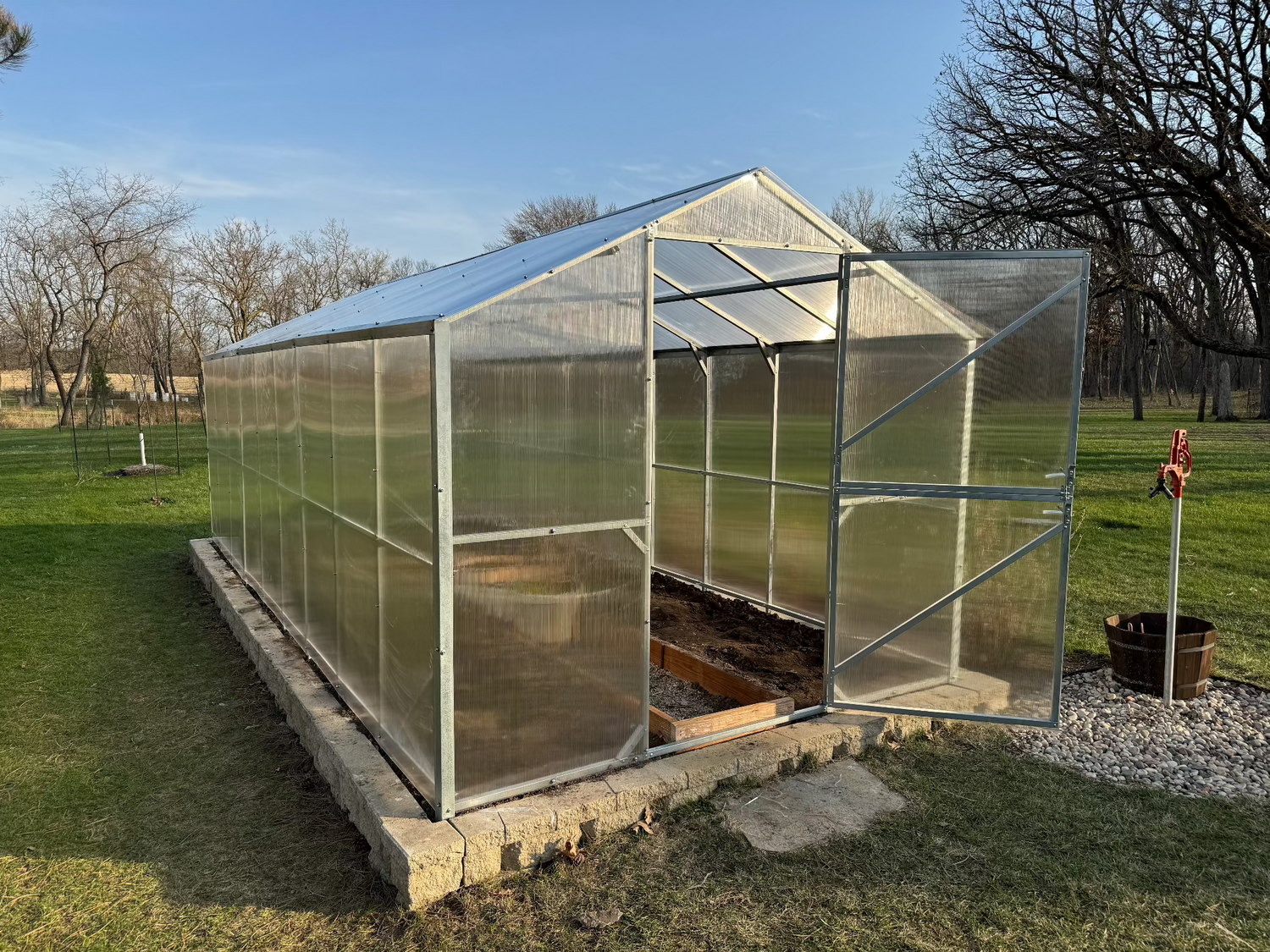 Heavy-duty greenhouse kit with galvanized steel frame and polycarbonate twin walls, designed to withstand harsh weather conditions.