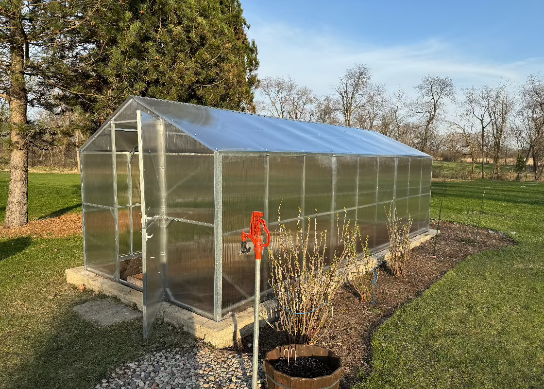 Heavy-duty greenhouse kit with galvanized steel frame and polycarbonate twin walls, designed to withstand harsh weather conditions.
