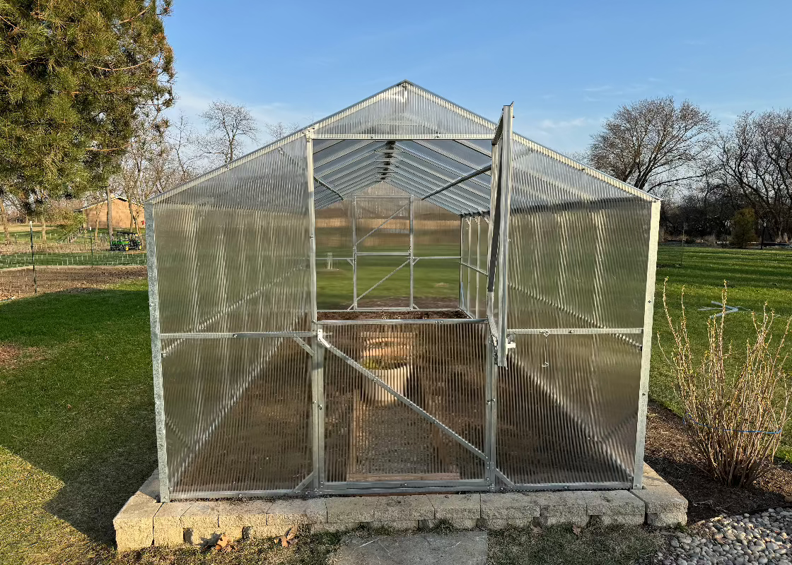 Heavy-duty greenhouse kit with galvanized steel frame and polycarbonate twin walls, designed to withstand harsh weather conditions.