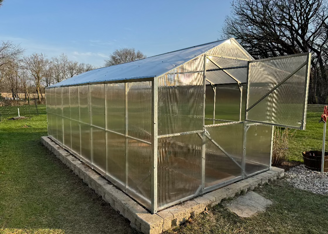 Heavy-duty greenhouse kit with galvanized steel frame and polycarbonate twin walls, designed to withstand harsh weather conditions.