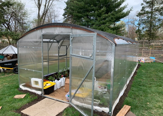 Heavy-duty greenhouse kit with galvanized steel frame and polycarbonate twin walls, designed to withstand harsh weather conditions.