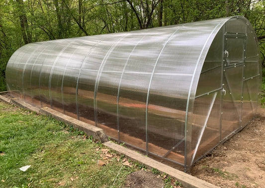 Heavy-duty greenhouse kit with galvanized steel frame and polycarbonate twin walls, designed to withstand harsh weather conditions.