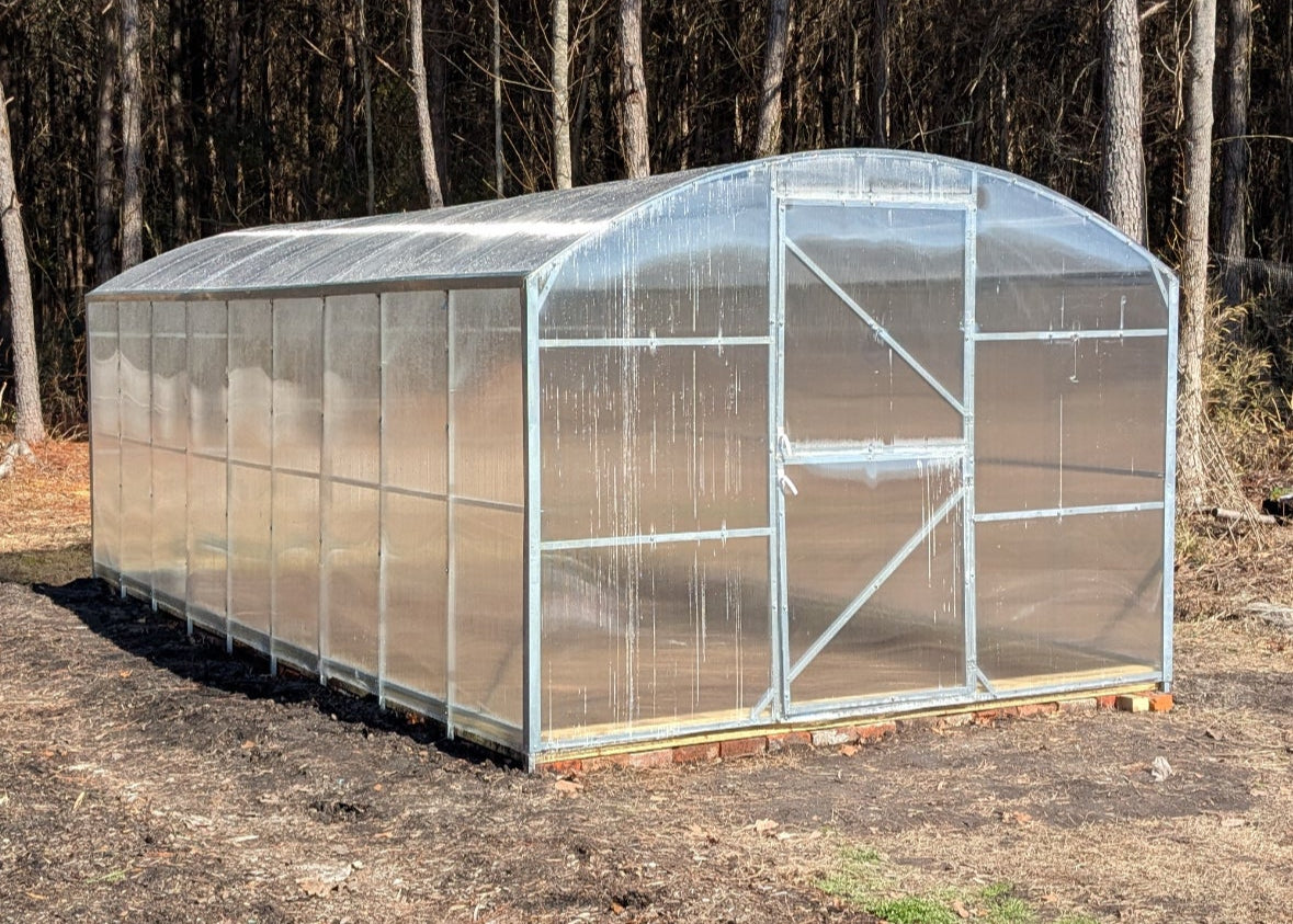 Heavy-duty greenhouse kit with galvanized steel frame and polycarbonate twin walls, designed to withstand harsh weather conditions.