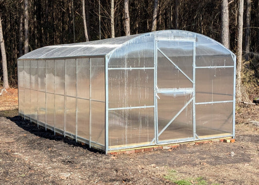 Heavy-duty greenhouse kit with galvanized steel frame and polycarbonate twin walls, designed to withstand harsh weather conditions.