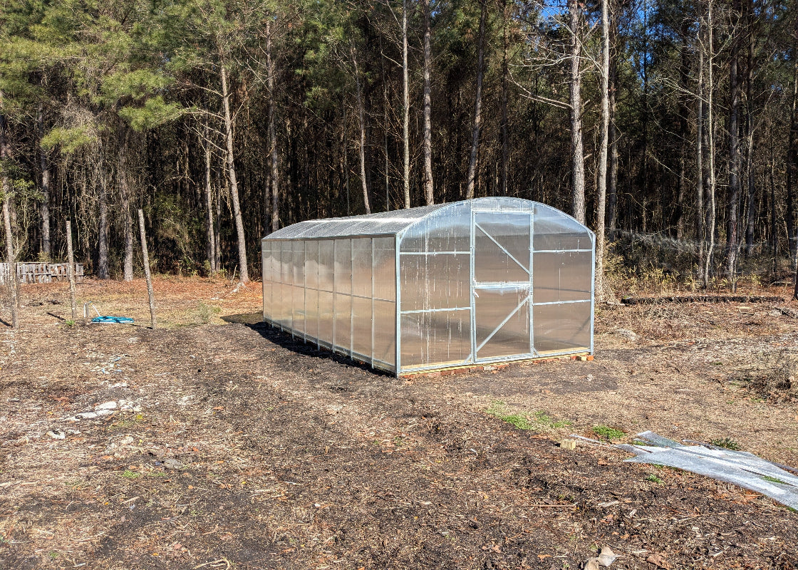 Heavy-duty greenhouse kit with galvanized steel frame and polycarbonate twin walls, designed to withstand harsh weather conditions.