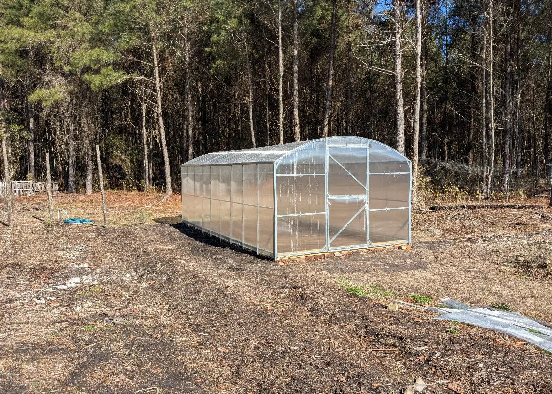 Heavy-duty greenhouse kit with galvanized steel frame and polycarbonate twin walls, designed to withstand harsh weather conditions.