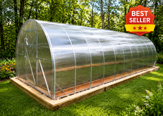 A long arched greenhouse with a transparent plastic cover and wooden frame, sitting on a raised wooden base in a grassy backyard with trees in the background. A red and yellow 'BEST SELLER' badge is in the top right corner.